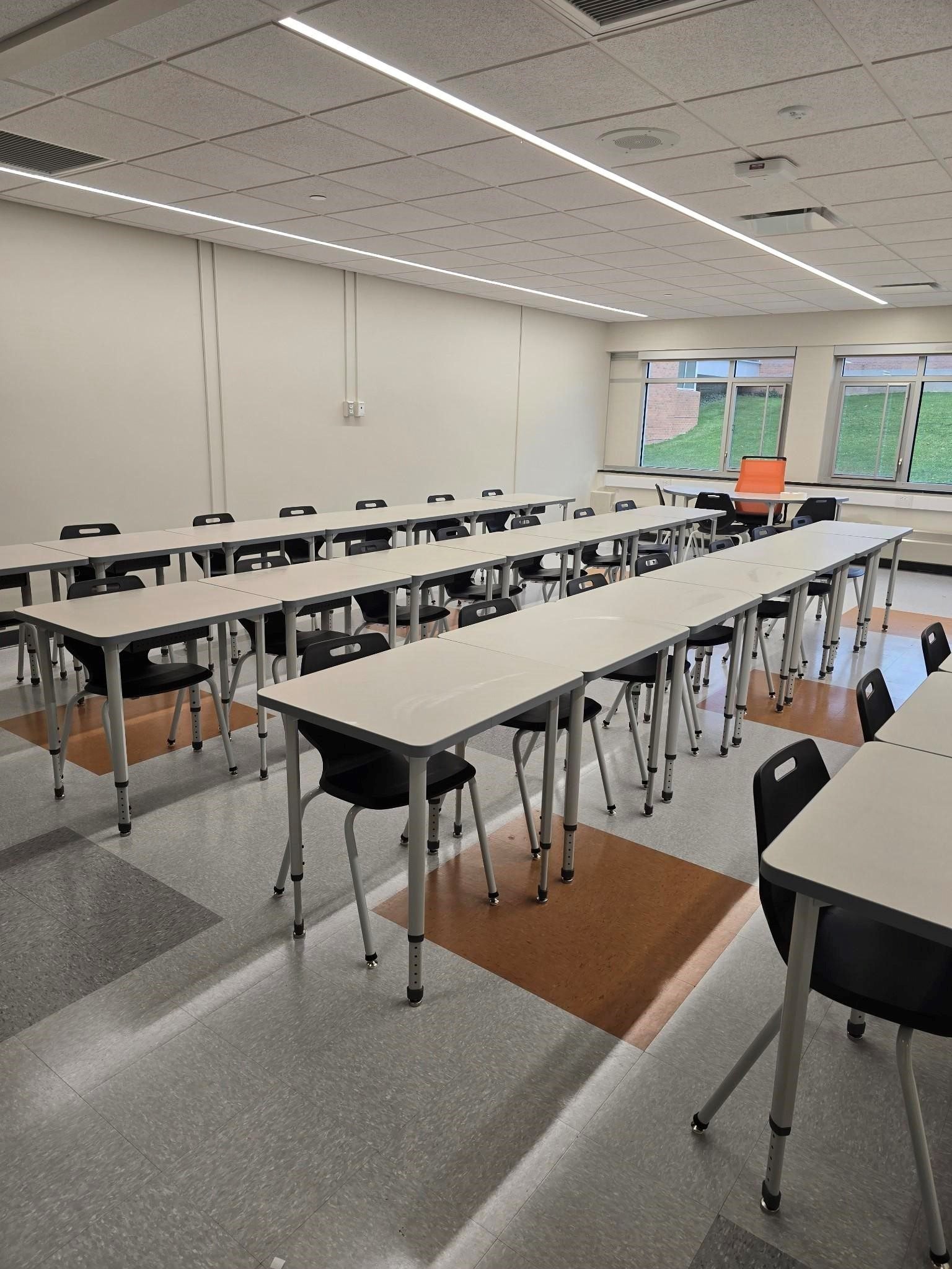 Finished modular classroom interior with student desks, chairs, and linear LED lighting