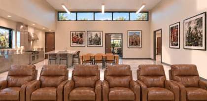 Day room with leather recliners and open kitchen